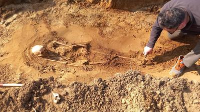 Un archeologo impegnato nella campagna di scavi in corso sotto l’argine sinistro dell’Adige DIENNE FOTO
