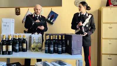 I carabinieri con le bottiglie rubate, sequestrate nelle abitazioni degli indagati
