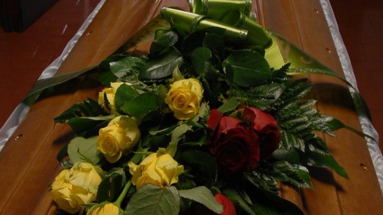 Sulla bara in legno chiaro  le rose che simboleggiano l’affetto dei familiari:   tre rosse, una bianca e sei gialle  FOTO PECORA