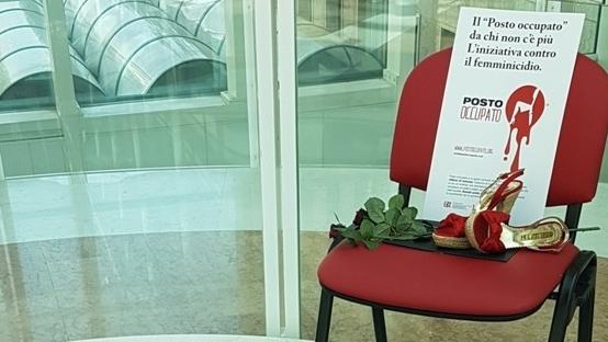 Una sedia rossa, scarpe femminili dello  stesso colore, quello della protesta contro le uccisioni di donne