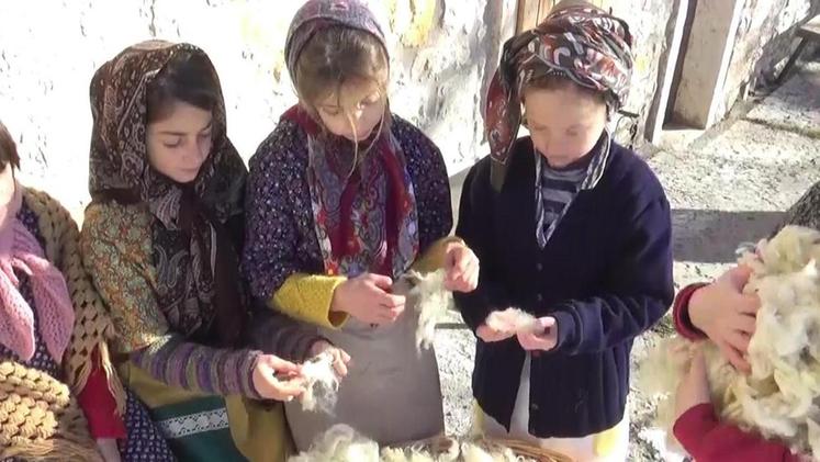 Una scena di «Calda montagna» con i bambini in costume che lavorano la lana