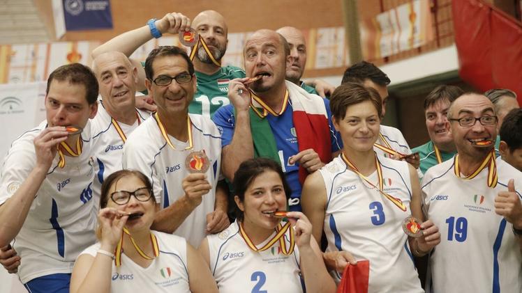 L’atleta Barbara Perpenti, con il numero 2, “addenta” la medaglia con i suoi compagni di squadra