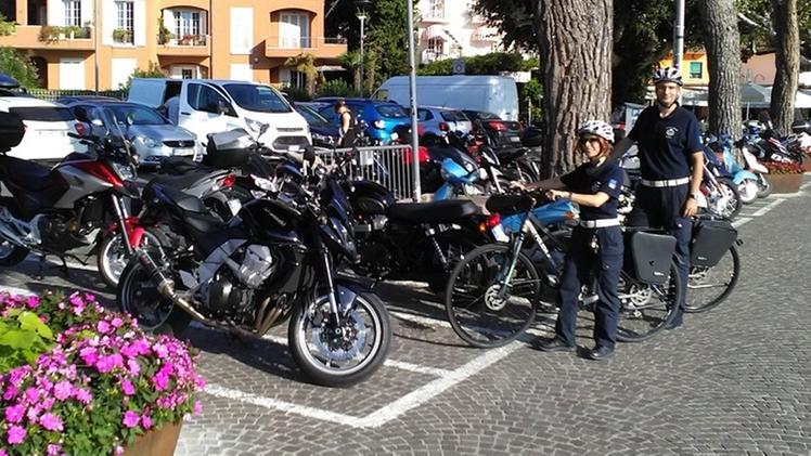 Agenti della polizia municipale davanti ad alcuni stalli di sosta per le motociclette