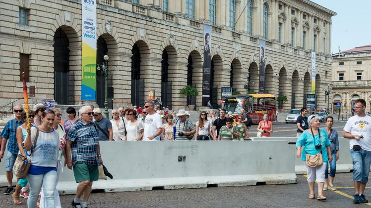 I turisti fanno dribbling tra le barriere anti-camion installate in piazza Bra dopo l’attacco di Barcellona: resteranno fino a fine settembre FOTOSERVIZIO MARCHIORI
