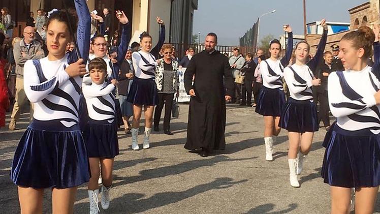 Don Michele De Rossi fa il suo ingresso  in parrocchia a Menà circondato dalle majorettes 