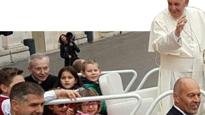 Papa Francesco, mentre benedice la folla, sorride ai piccoli passeggeri fatti salire sulla sua auto