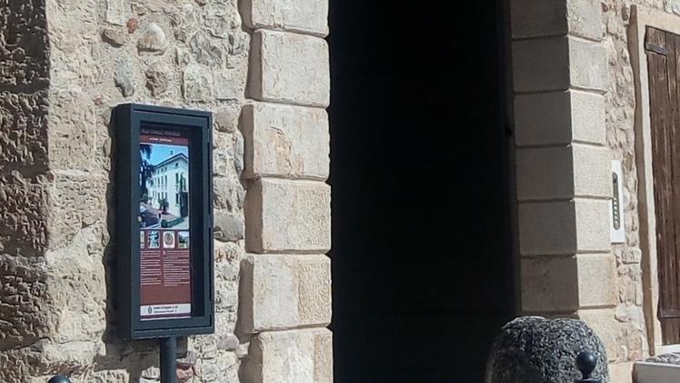 Una bacheca davanti a un palazzo storico in piazza Roma