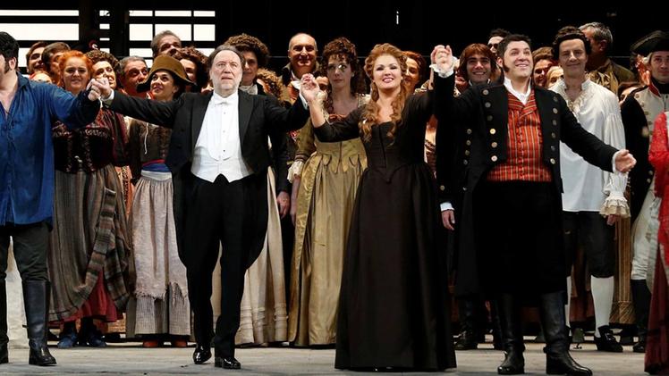 Cantanti e figuranti rispondono al lungo applauso degli spettatori della Scala al termine dell’«Andrea Chénier» inaugurale