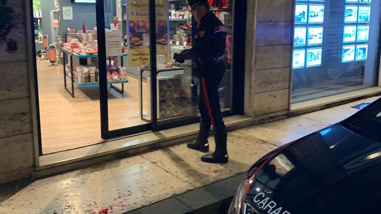 Un carabiniere davanti al negozio danneggiato