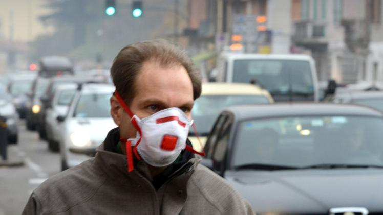 Un uomo si ripara dallo smog con la mascherina in corso Milano, una delle strade più inquinate della città