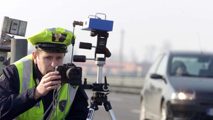 Un agente con il telelaser e la macchina fotografica per «immortalare» il rispetto della velocità di veicoli 