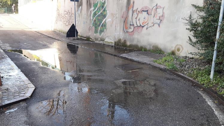 L’acqua che affiora dal tombino dietro le scuole Pisanello