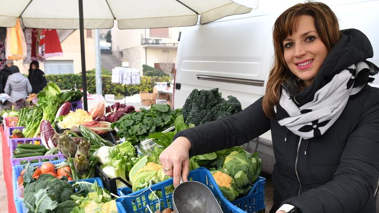 La cantante Elena Camocardi al suo banco di frutta e verdura