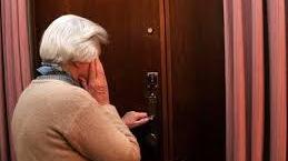 Un'anziana apre la porta di casa