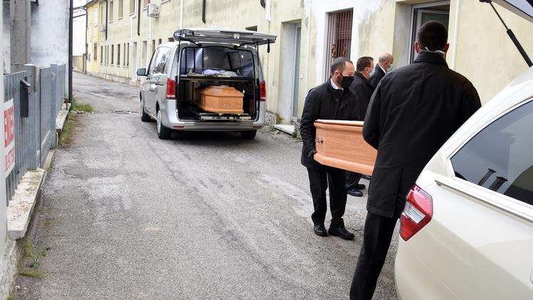 Gli addetti delle pompe funebri trasportano le bare di due anziani morti alla casa di riposo