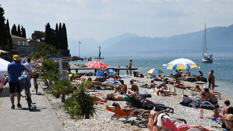 Turisti in spiaggia sul lago di Garda