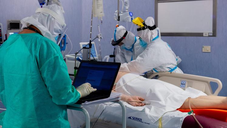 Medici e infermieri controllano le condizioni di un paziente Covid in un reparto di terapia intensiva