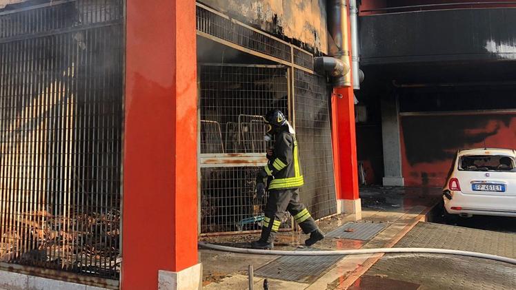 Un vigile del fuoco entra nel magazzino bruciato