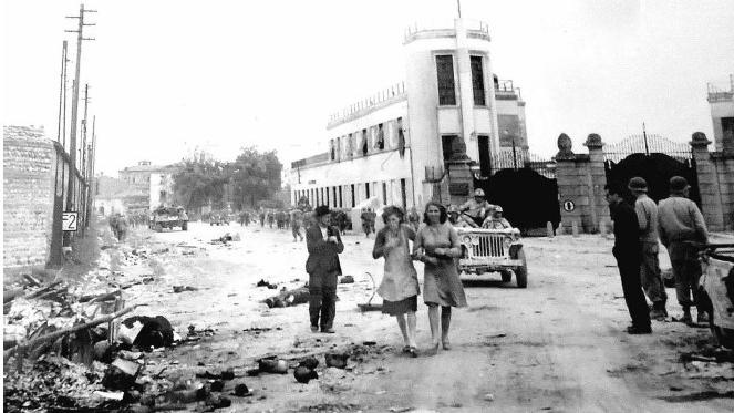 25 Aprile 1945. Gli Americani davanti all’ingresso dei Magazzini Generali: a terra i morti degli ultimi scontri