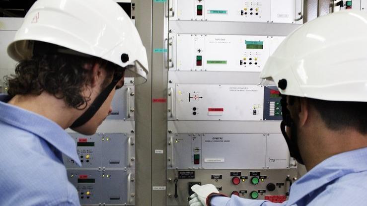 Tecnici Due operatori al lavoro sull’impianto di una centralina elettrica