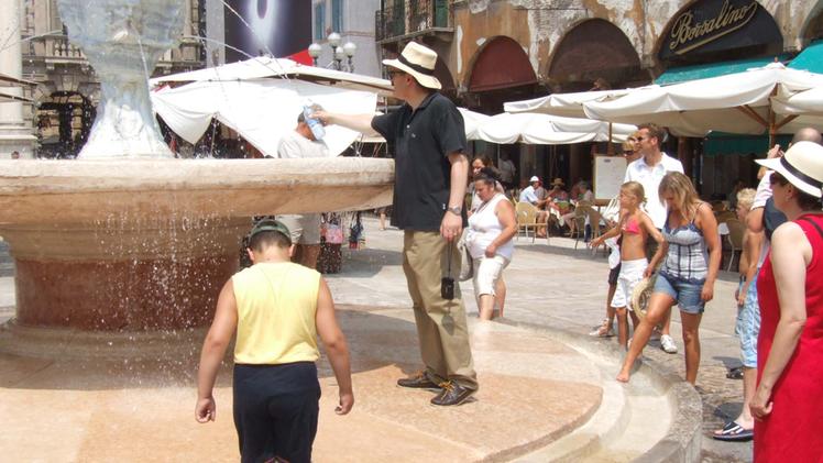 Turisti cercano refrigerio alla fontana di Madonna Verona