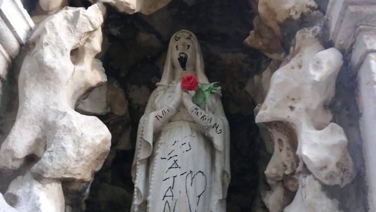 Scritte e disegni in pennarello indelebile sulla statua della Madonna