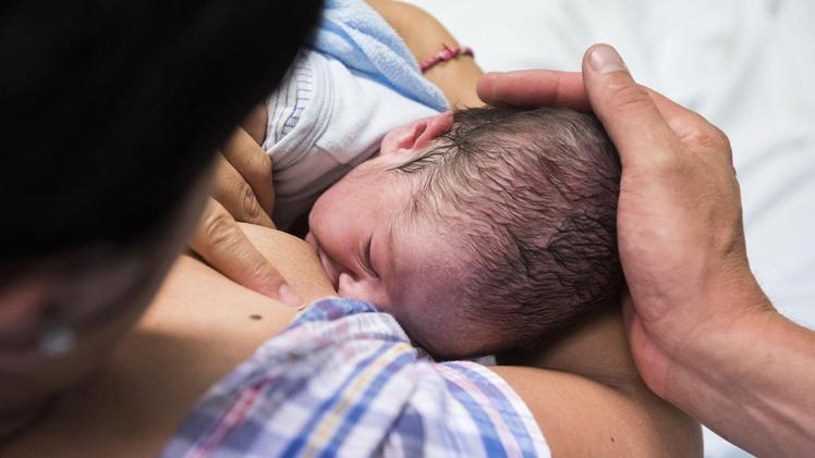 Una donna allatta il figlio appena nato